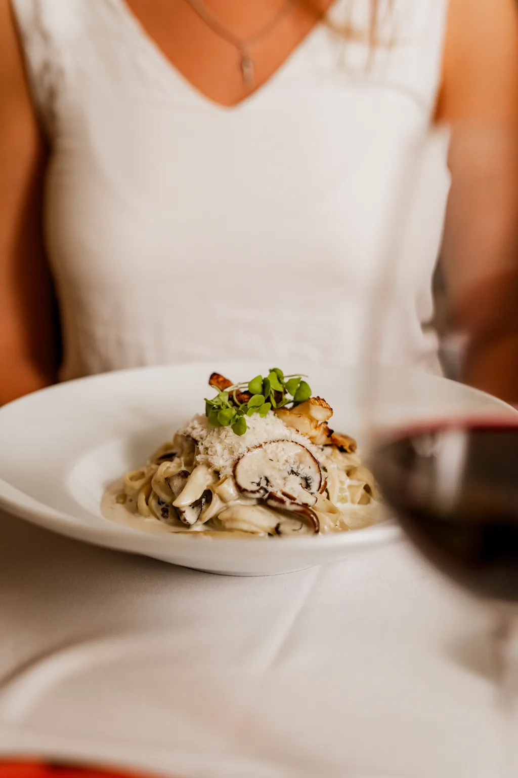 Tagliatelle de cogumelos servido à mesa, com vinho tinto