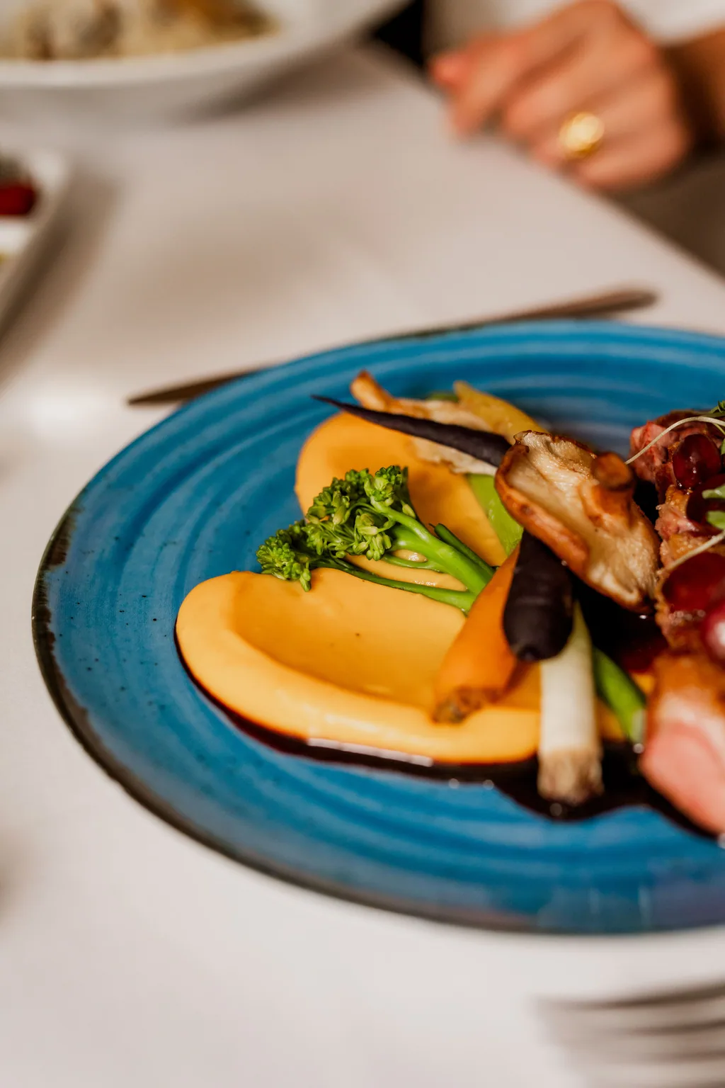 Gebratenes Fleisch mit Spargel und Püree auf blauem Teller