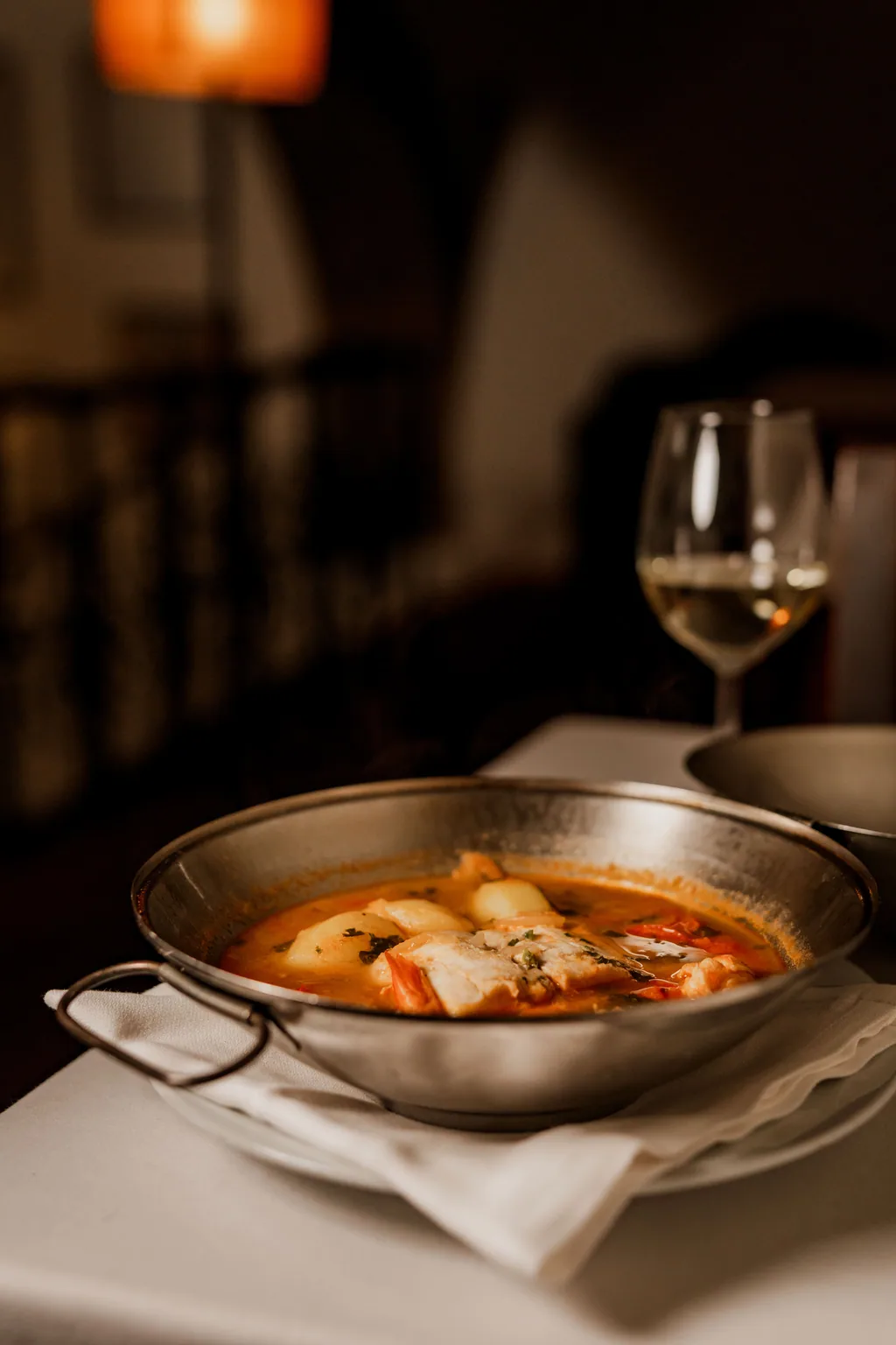 Dampfende Fisch-Cataplana am Tisch
