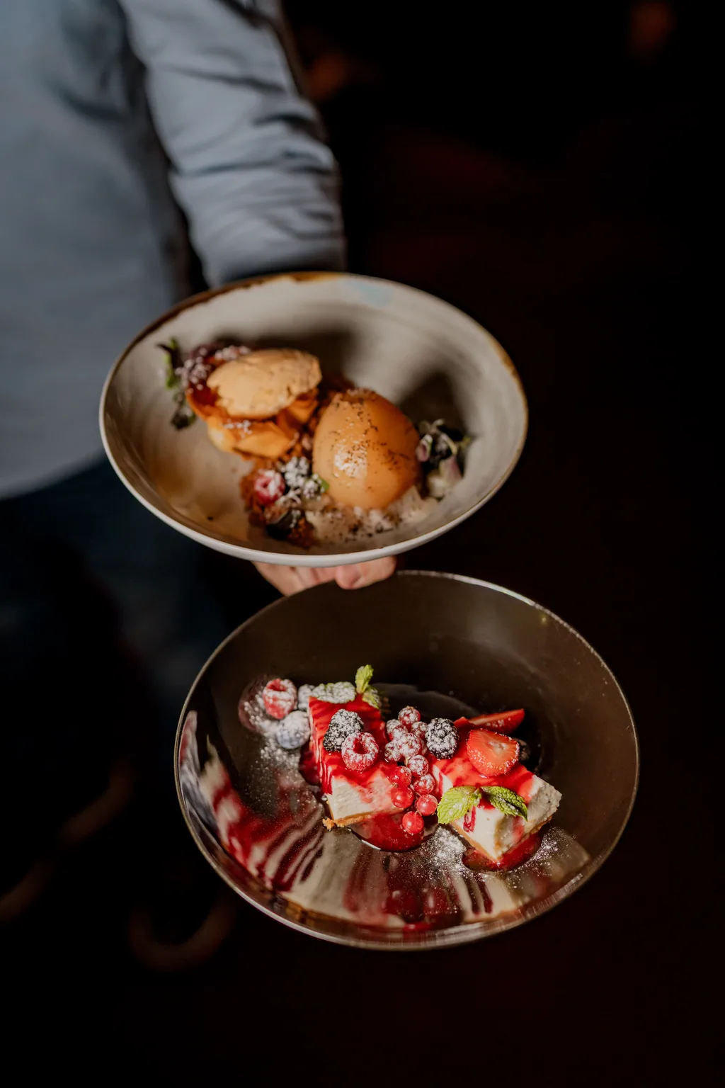 Desserts mit roten Früchten und Eis, vom Kellner getragen