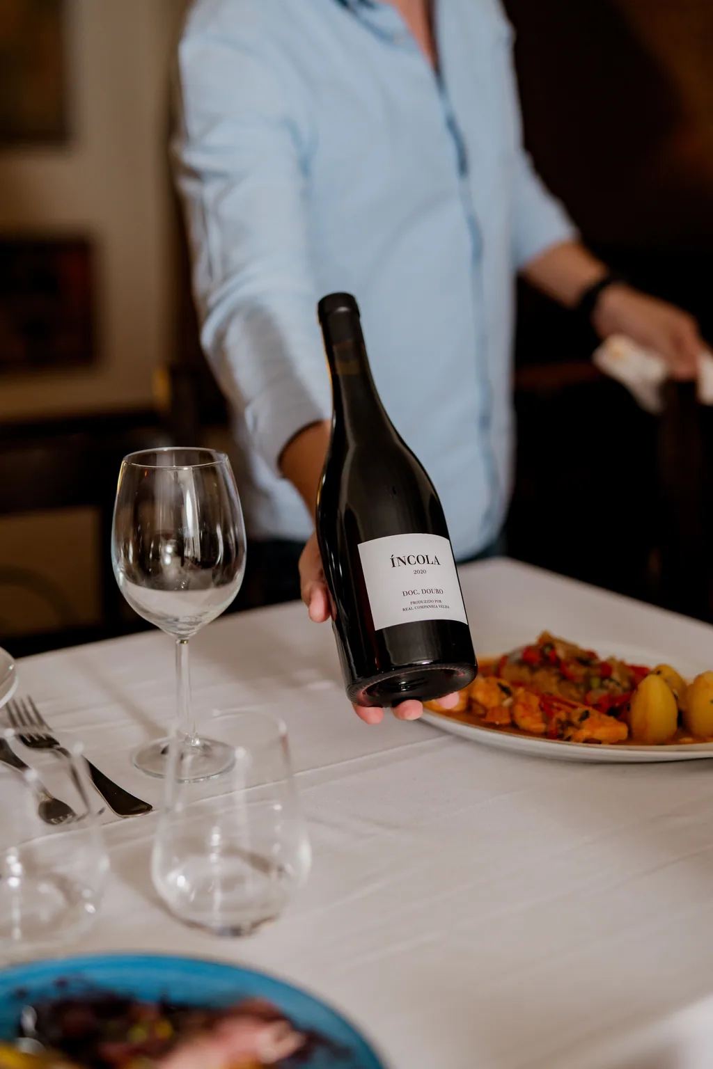 Der Kellner präsentiert eine Flasche Rotwein am Tisch