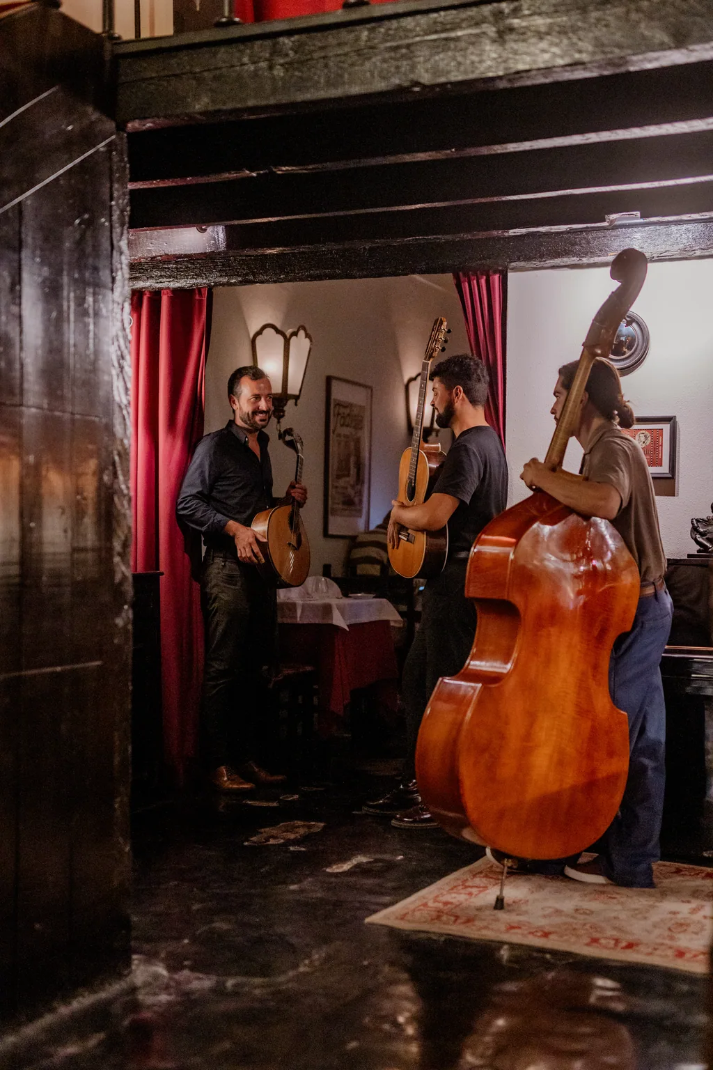 Das Ensemble — Gitarren und Kontrabass — zwischen roten Vorhängen