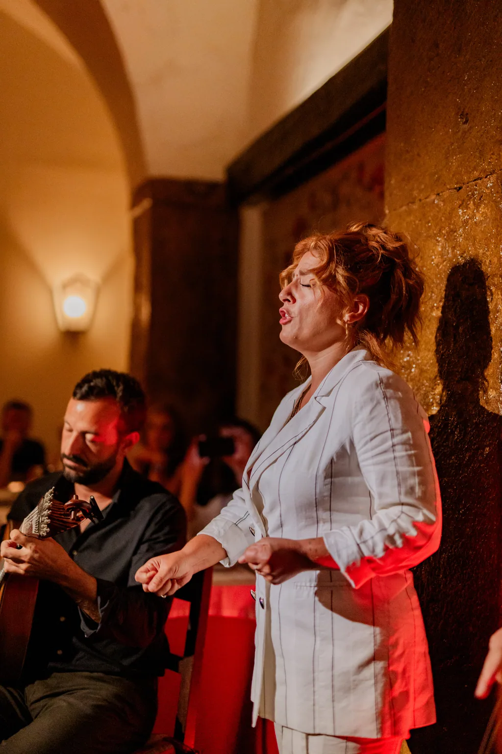 Fado-Sängerin singt mit geschlossenen Augen, der Gitarrist daneben