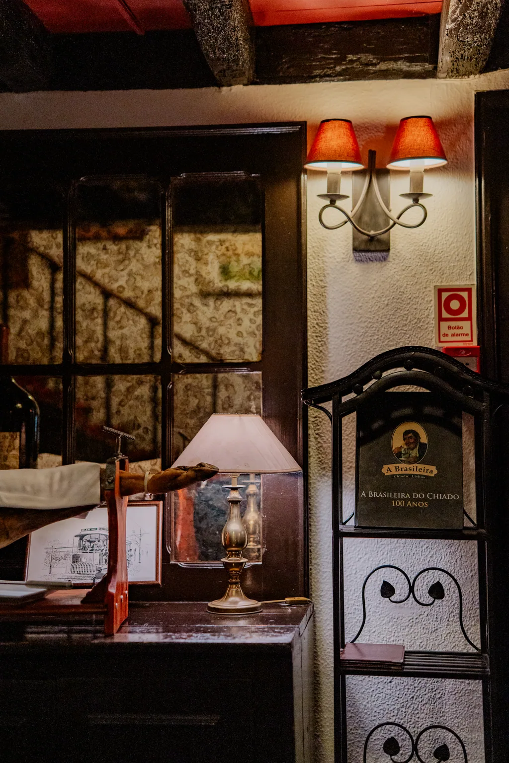 A corner of the house with an orange-shaded lamp and bare stone