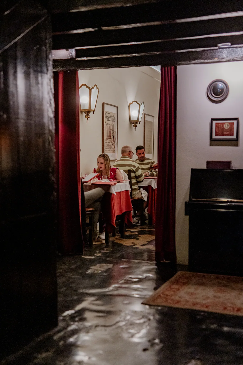 Corridor with the piano and the lit dining room beyond