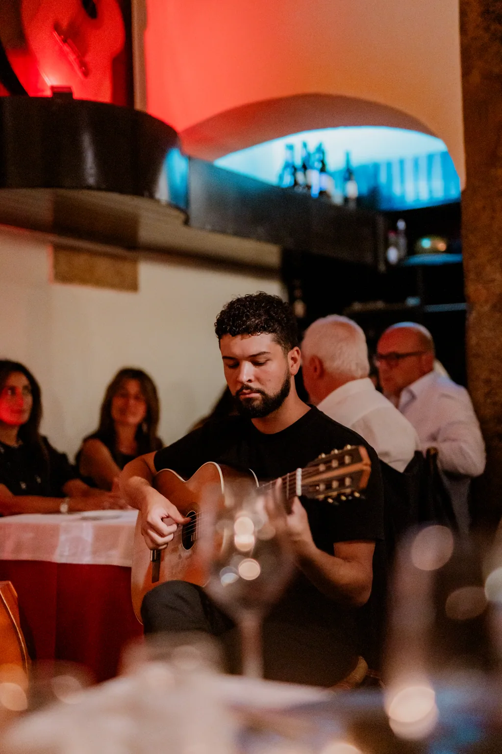 Guitarrista a tocar entre as mesas, com clientes a jantar à volta