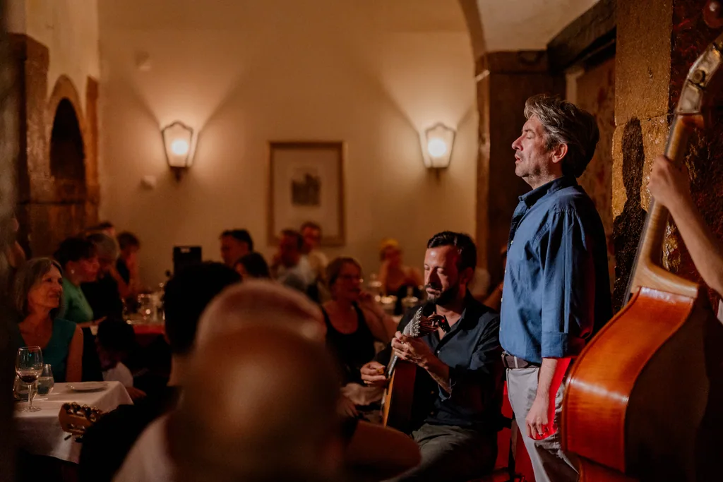 Der Saal des Clube de Fado in einer Fado-Nacht — der Sänger steht zwischen den Steinbögen und den Tischen