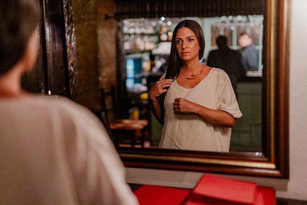 Fado singer reflected in the mirror of the house bar