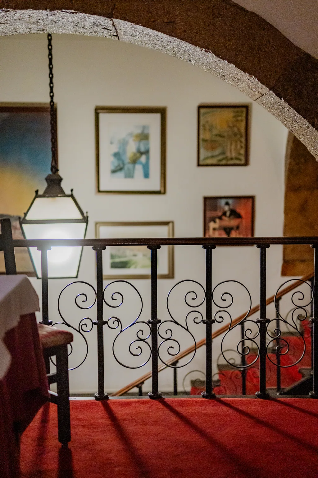 Wrought-iron staircase with framed pictures and the lantern