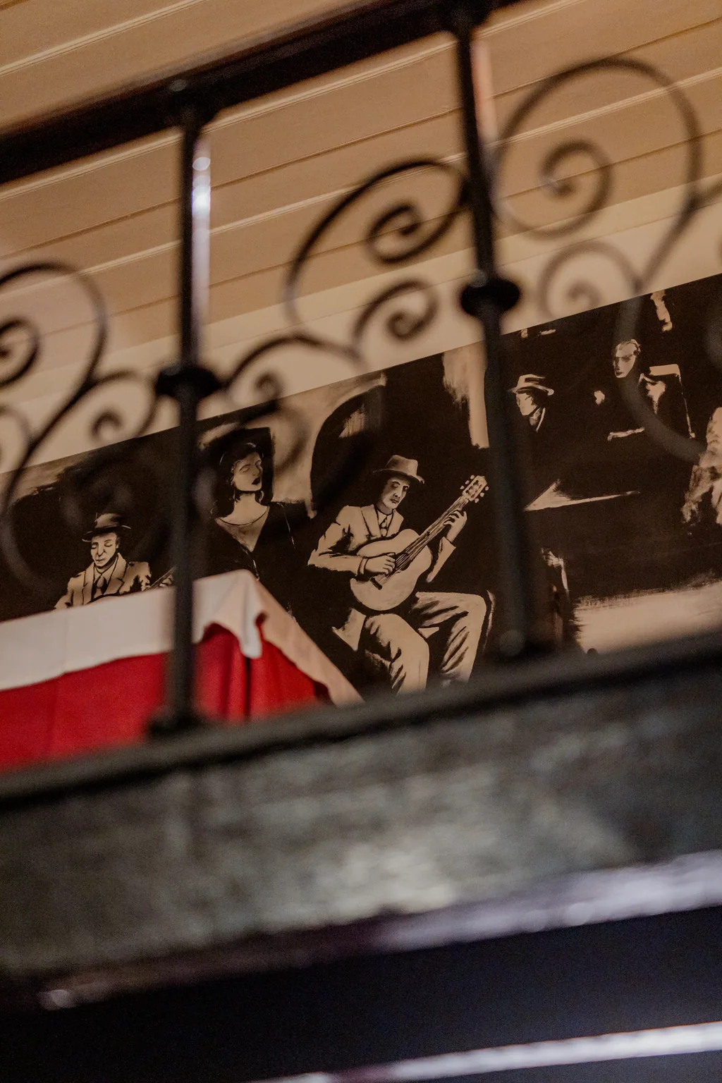 Wrought-iron balcony rail above the mural of fado singers