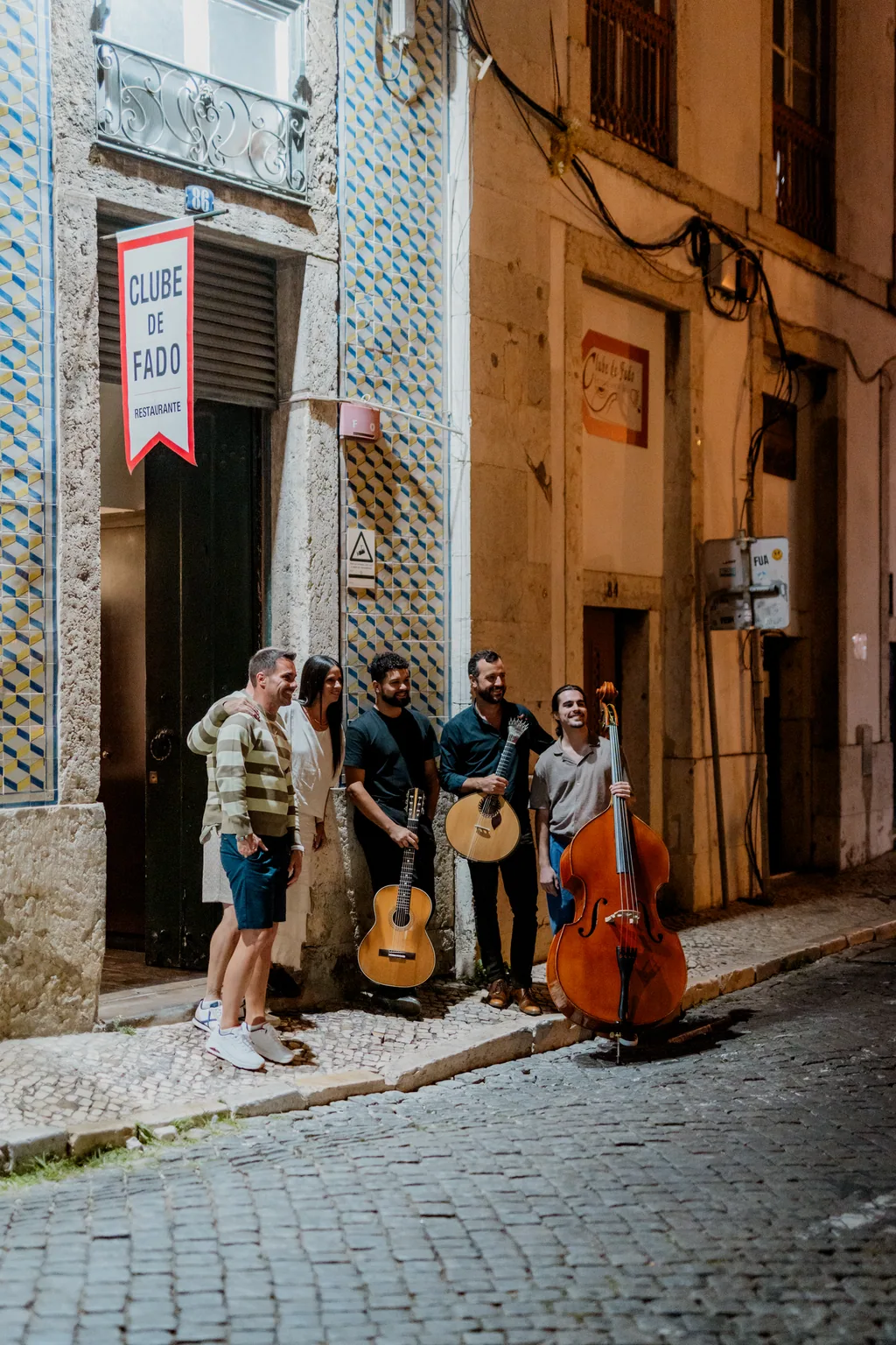 The musicians on the Alfama cobbles, instruments in hand