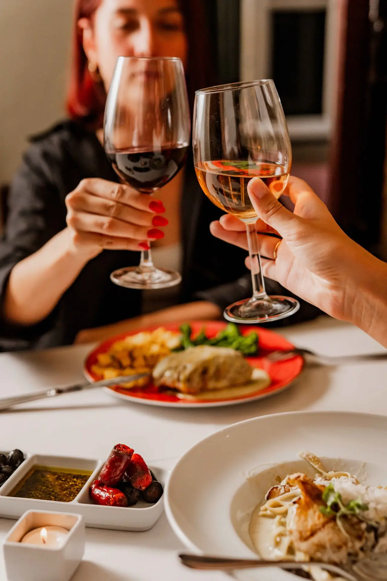 Casal a brindar com vinho durante jantar no Clube de Fado em Alfama, Lisboa